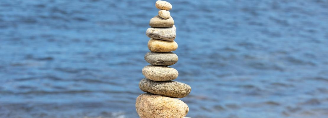 A serene landscape with smooth stones stacked, symbolizing balance and mindfulness.
